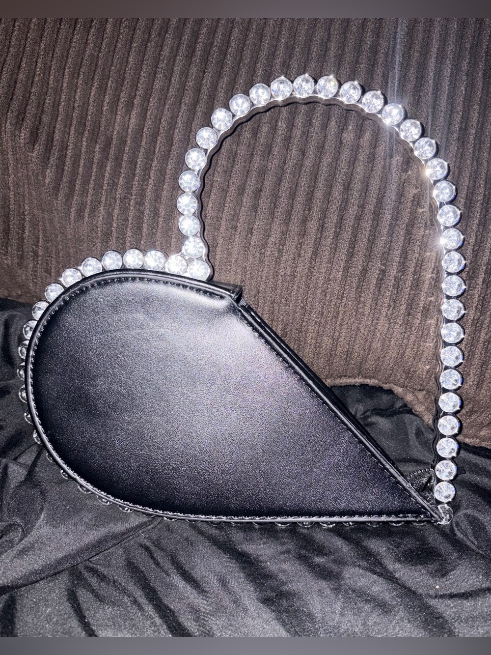 New black rhinestone-studded heart clutch bag.